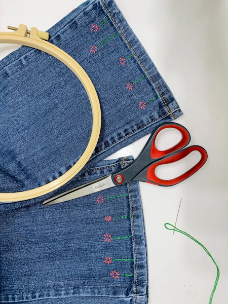 a pair of scissors sitting on top of a pair of jeans