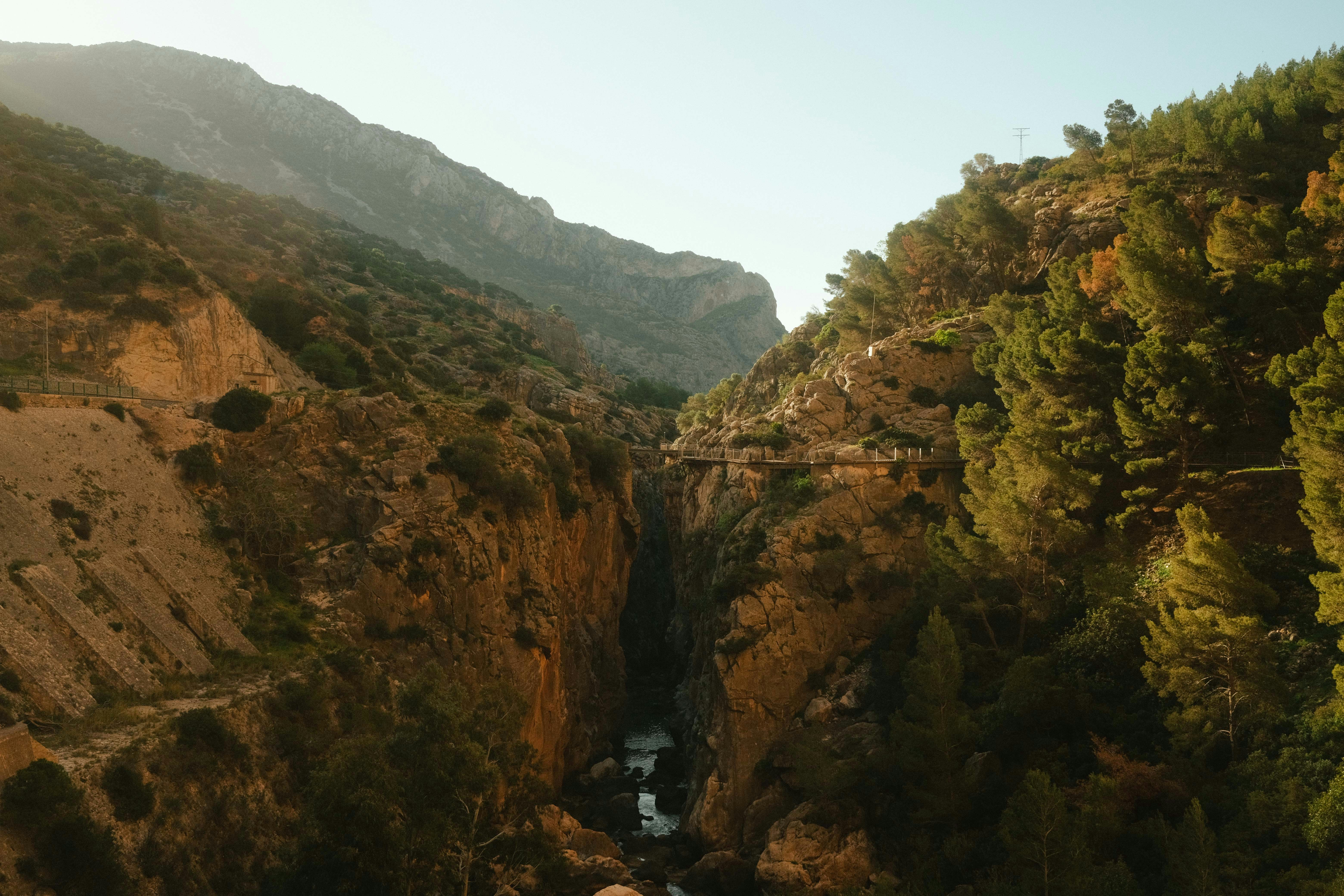 a bridge over a river in the middle of a mountain, Beautiful views at Caminito del Rey, near Malaga, early in the morning.