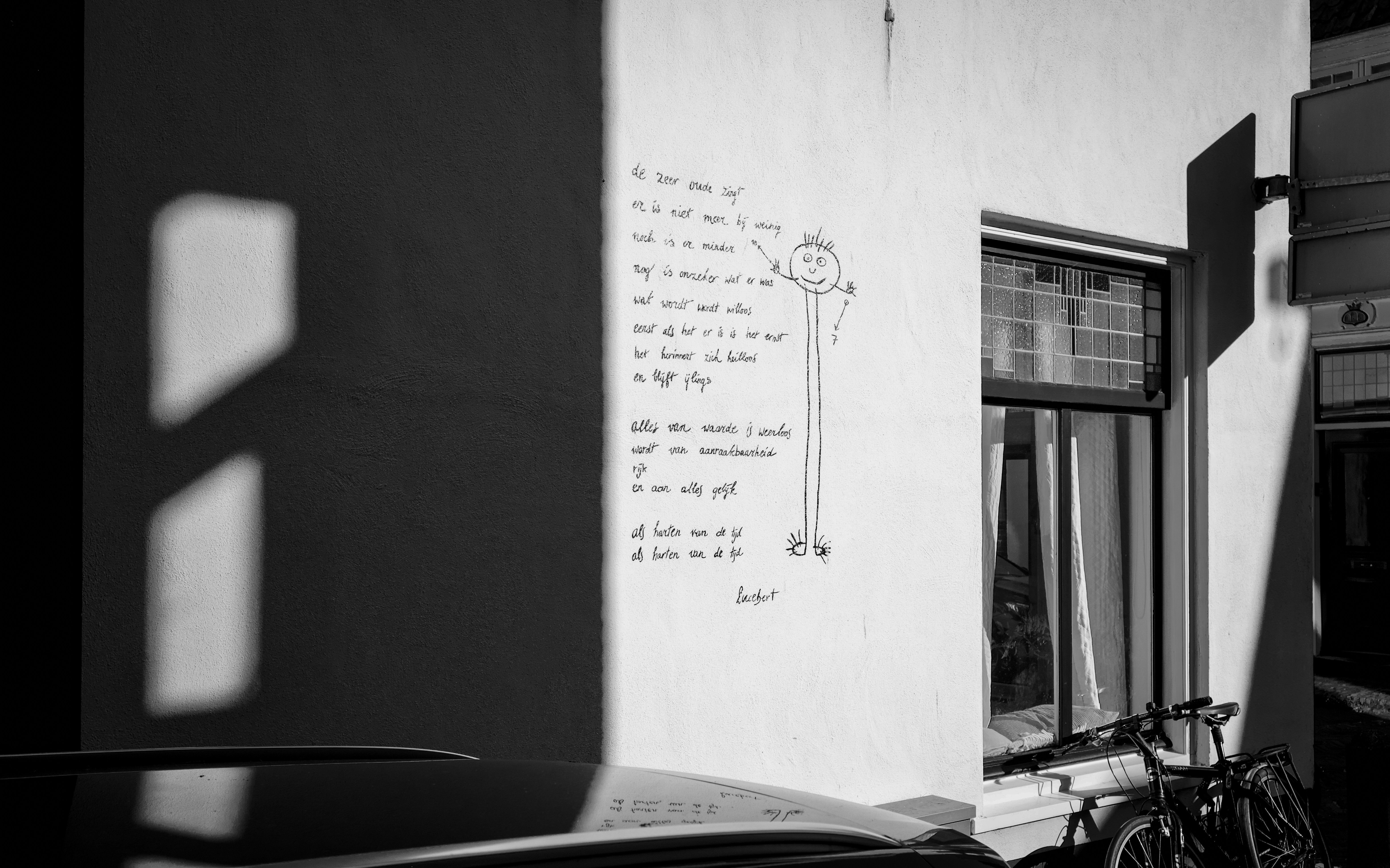 a black and white photo of a bike parked in front of a building