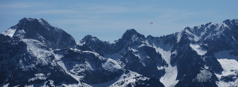 a group of mountains covered in snow under a blue sky