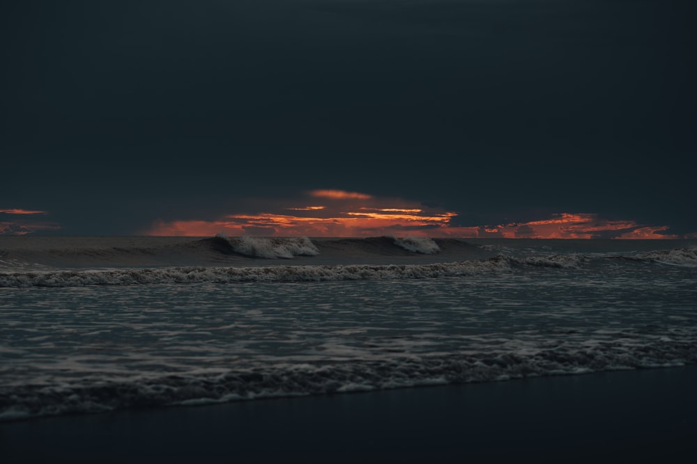 el sol se está poniendo sobre las olas del océano