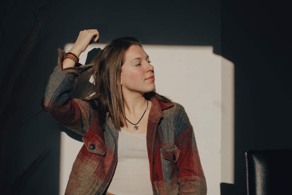 a woman standing in front of a white wall