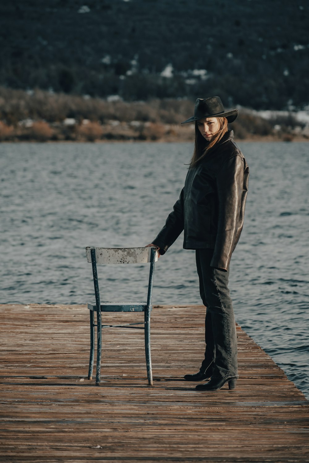 a woman standing on a dock next to a chair