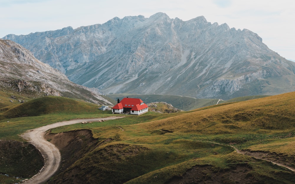 a red house in the middle of a mountain range