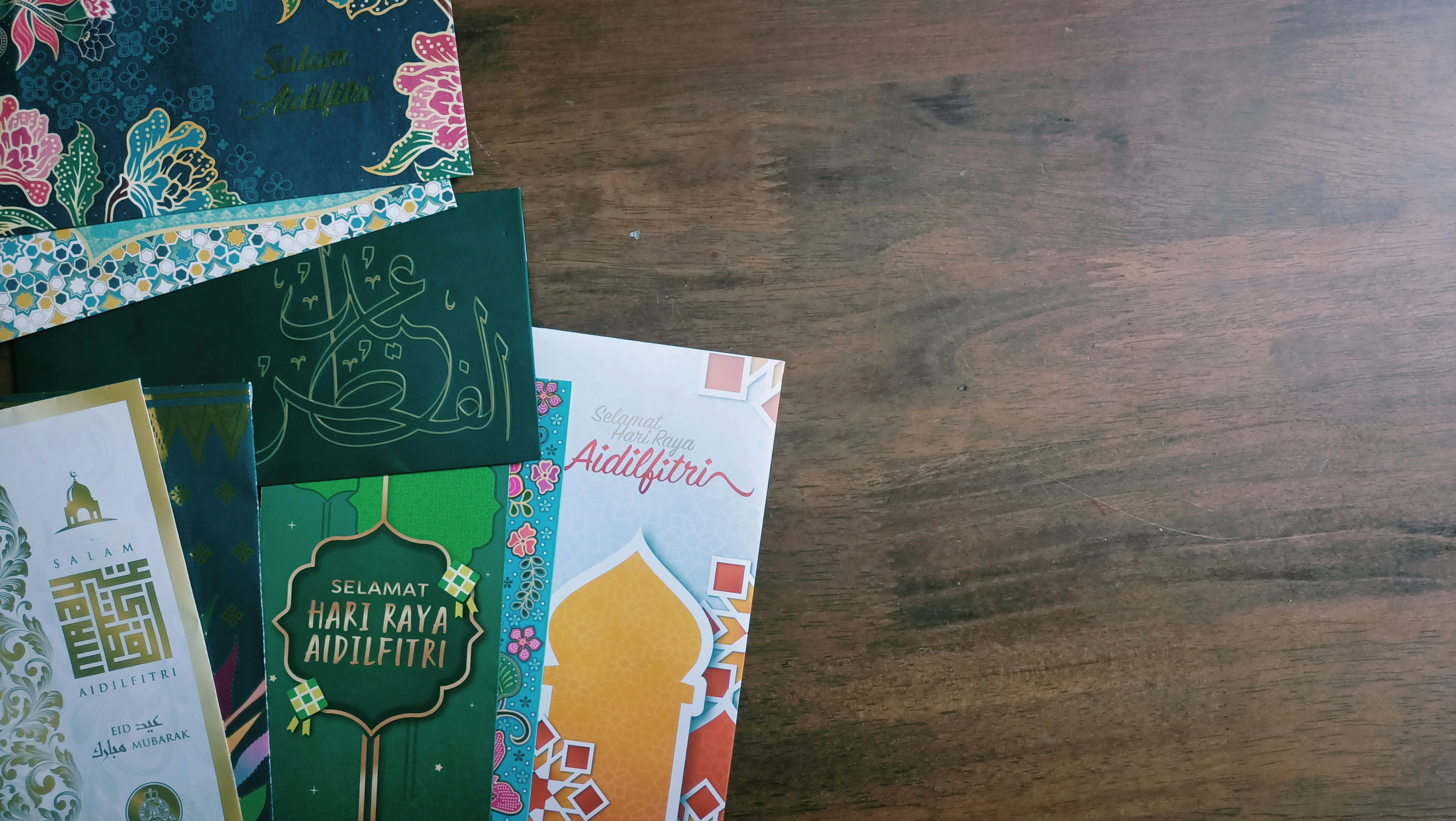 Colorful assortment of handmade greeting cards with floral designs spread on white surface