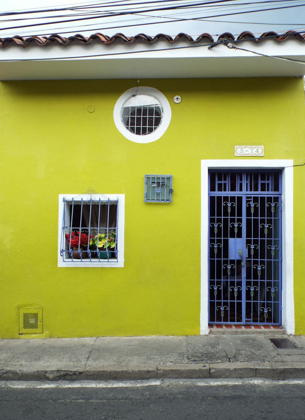 a yellow building with a white window and bars on it
