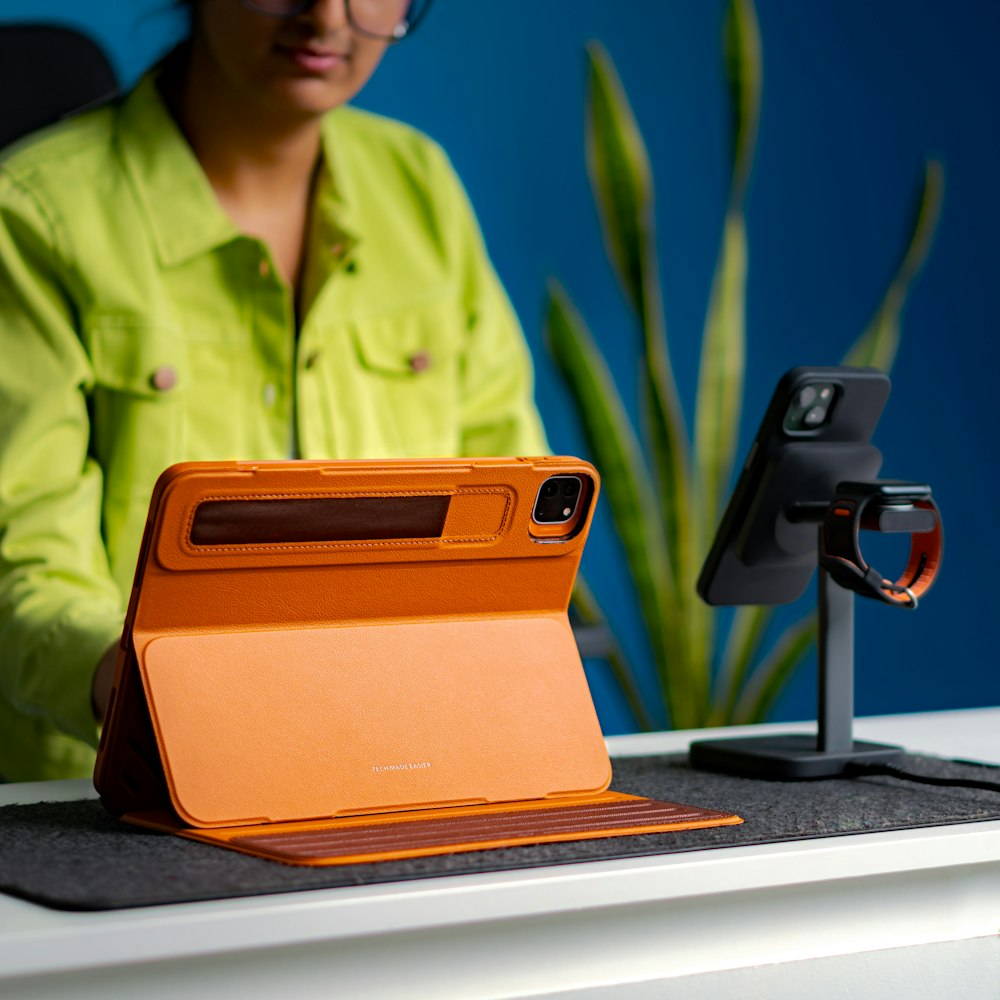 a woman sitting at a desk with an orange case