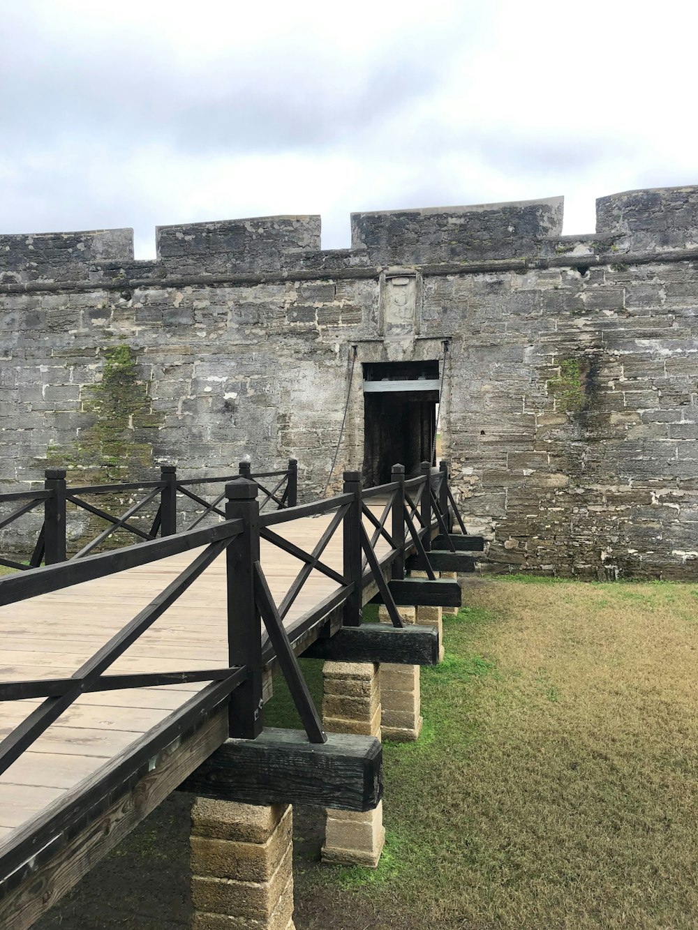 a wooden walkway leading to a stone building