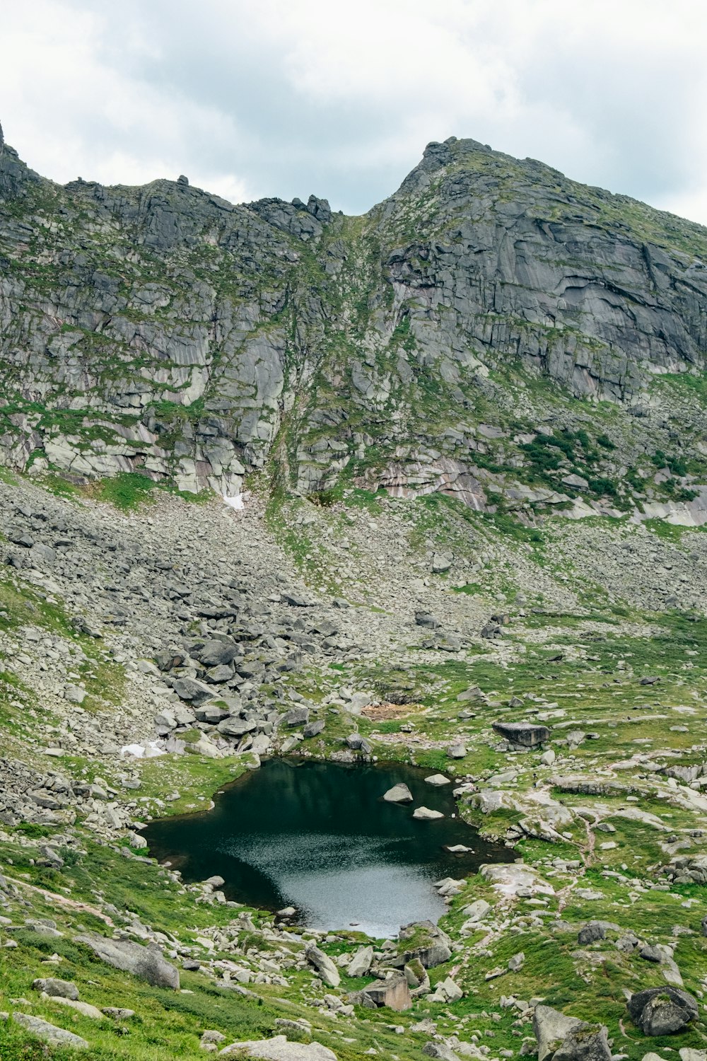 a mountain with a small lake in the middle of it