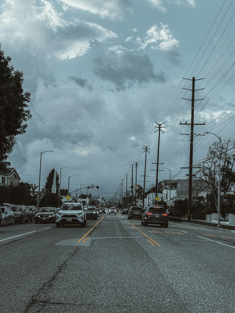a street filled with lots of traffic under a cloudy sky