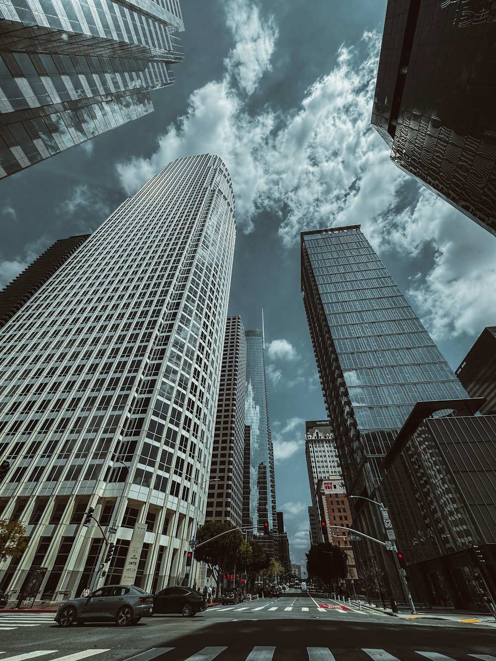 a city street filled with tall buildings under a cloudy sky