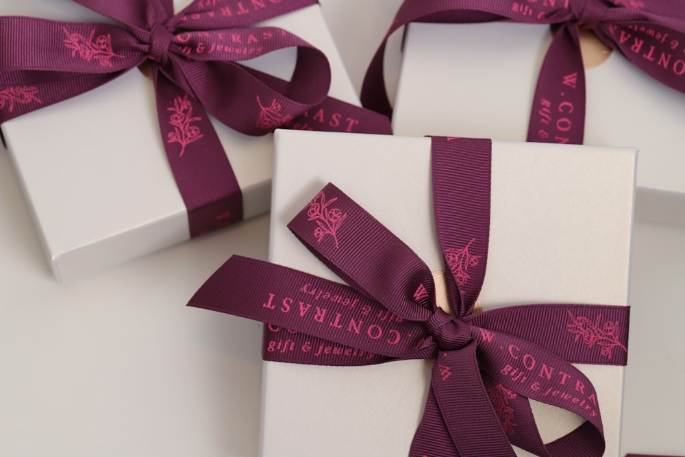 a close up of three wrapped presents with ribbons