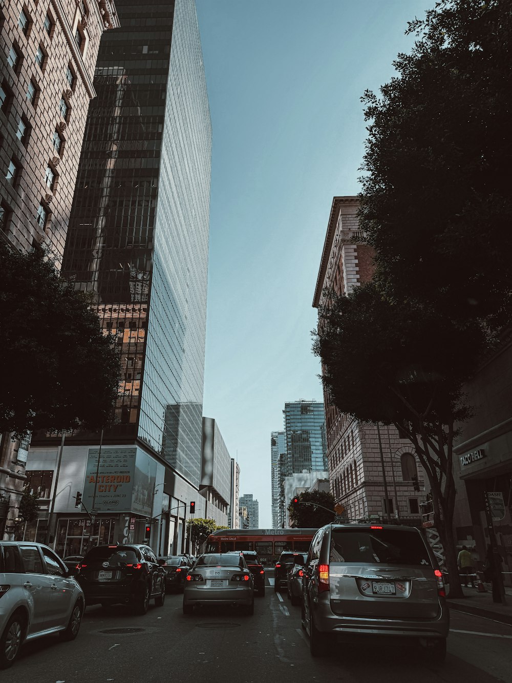 a city street filled with lots of traffic next to tall buildings