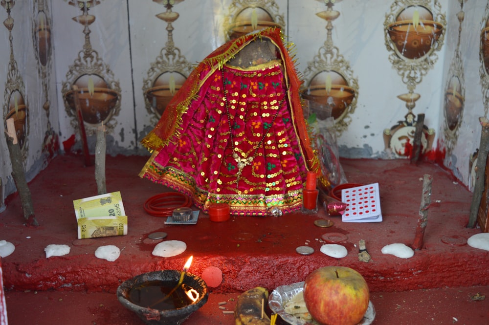 a woman in a red and gold outfit sitting in a room