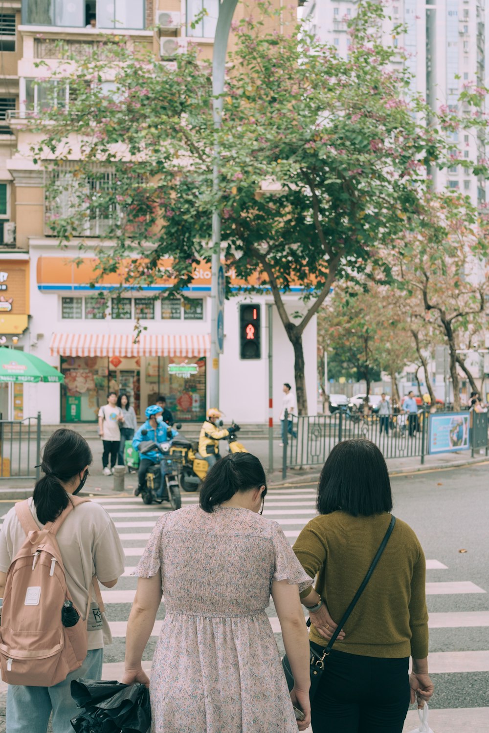 a group of people walking across a cross walk