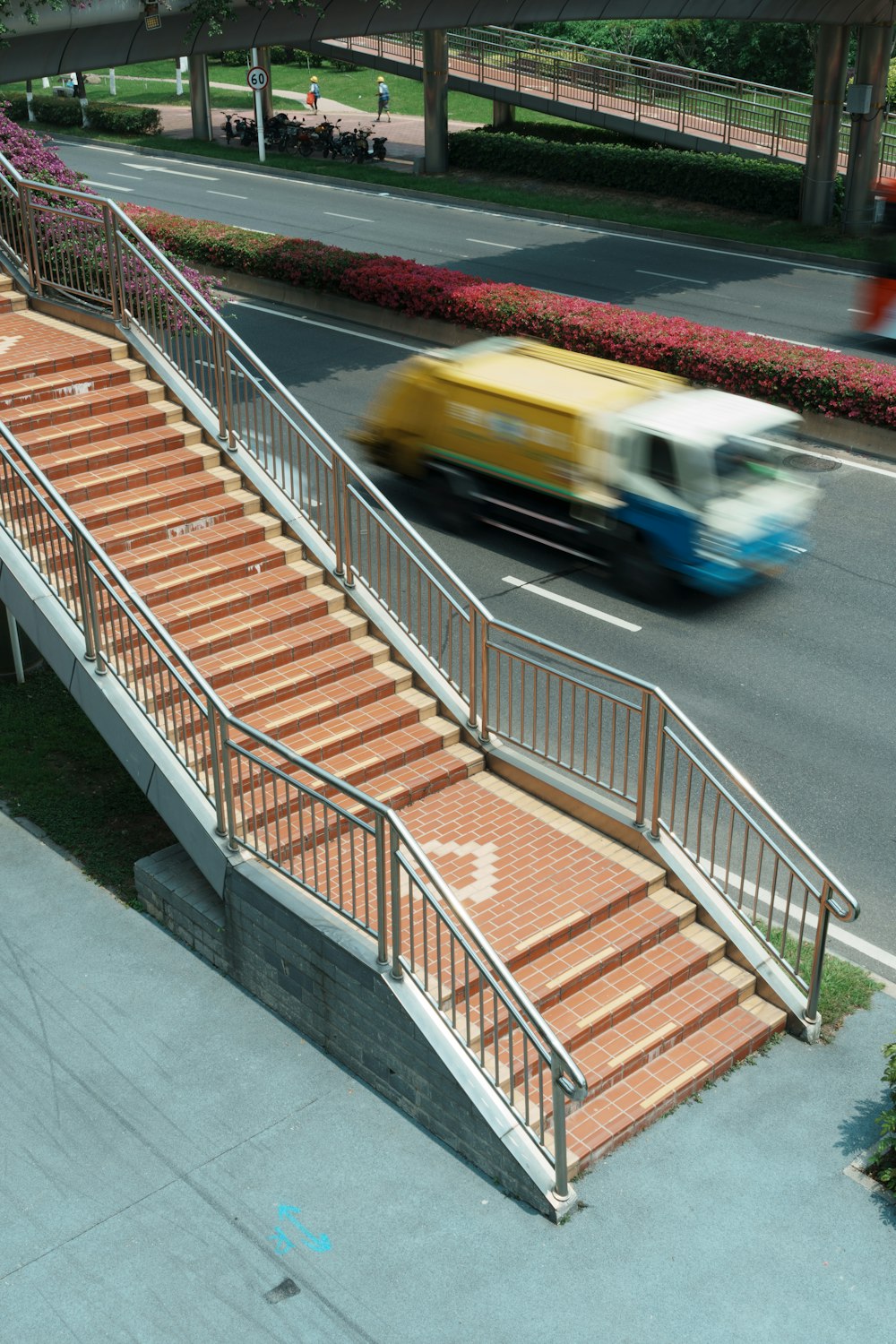 a bus driving down a street next to a set of stairs