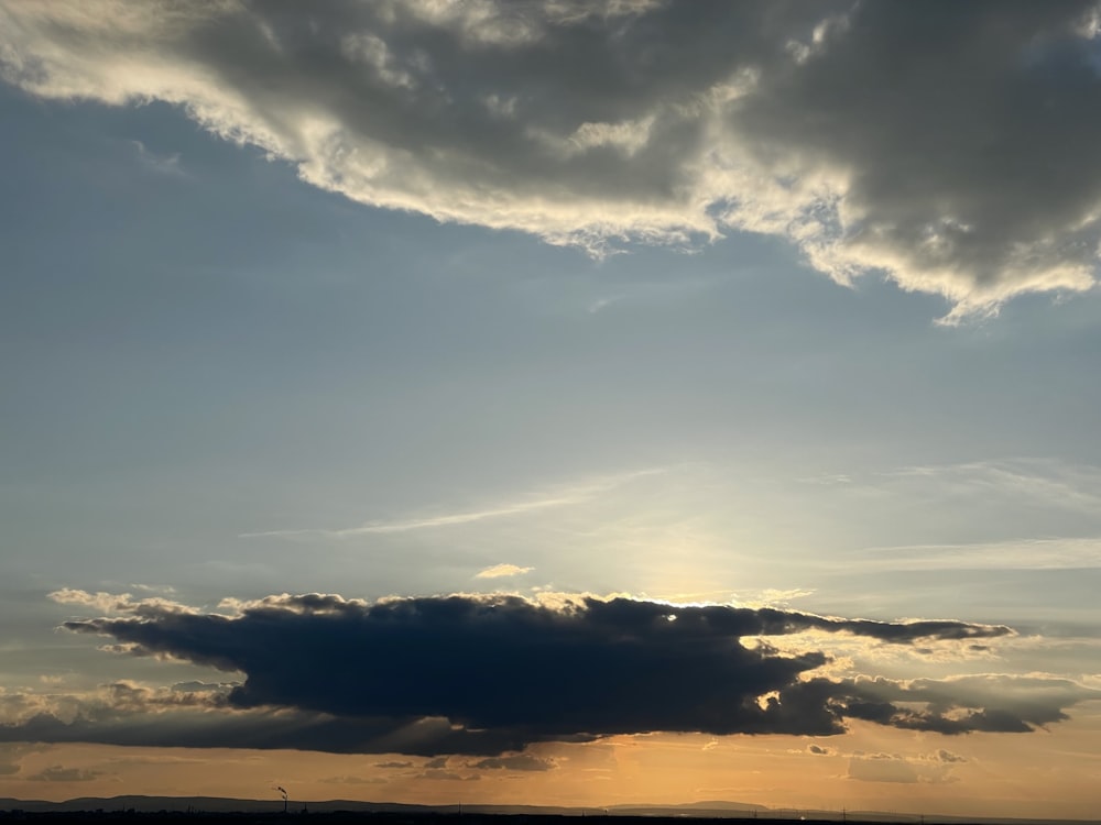 a large cloud is in the sky over a field