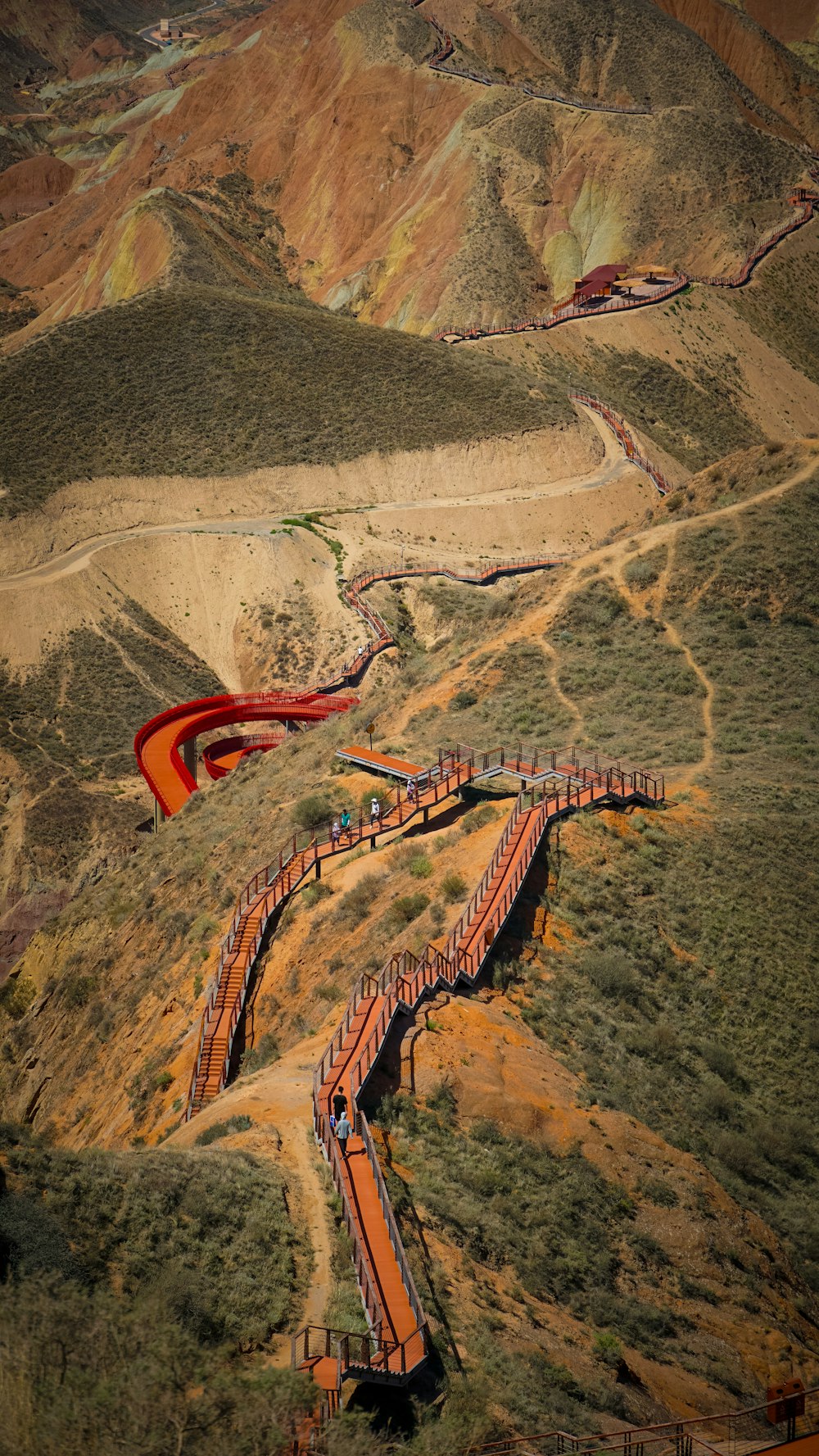 an aerial view of a train on a track in the mountains