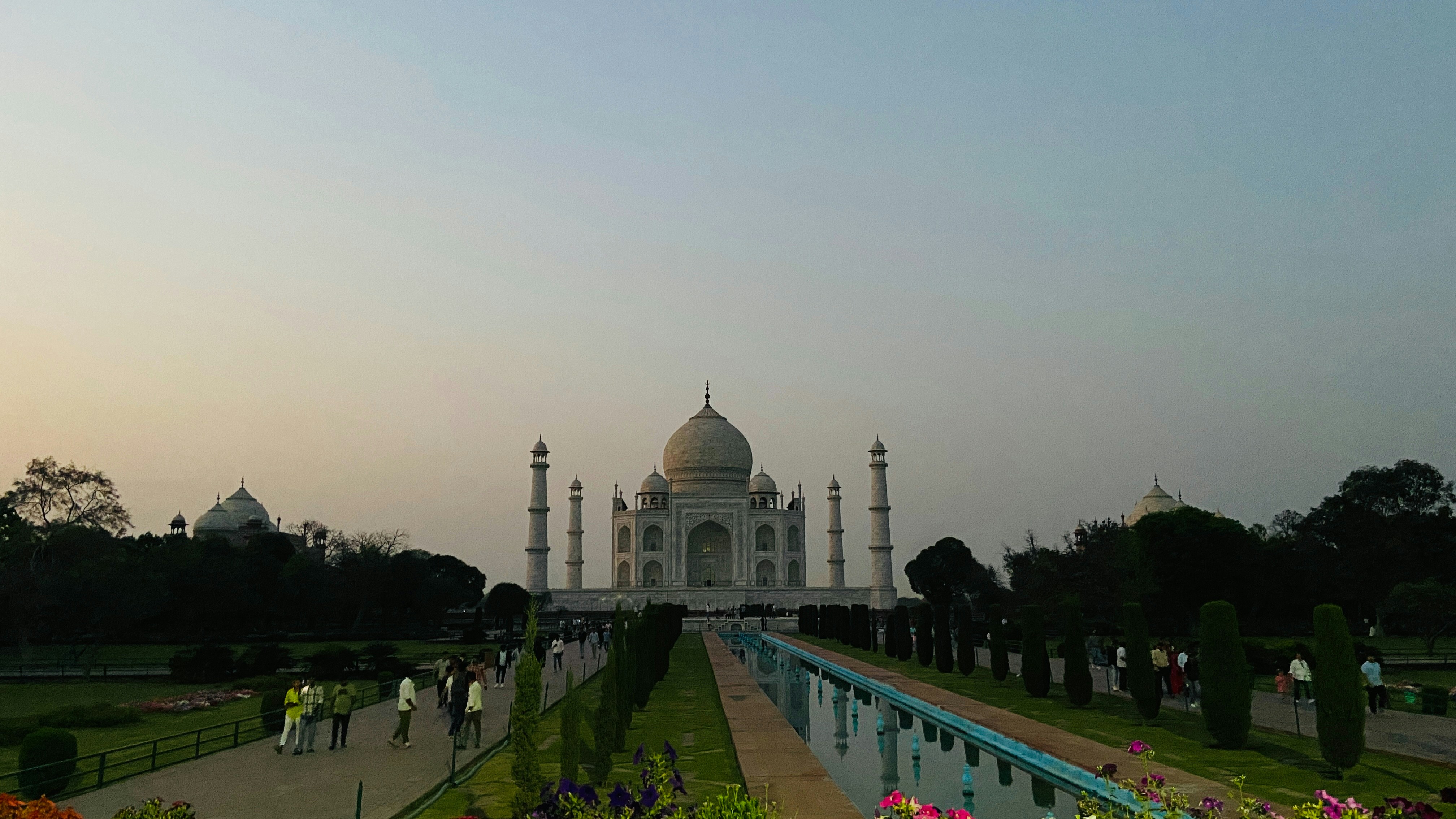 um grande edifício branco com uma piscina em frente