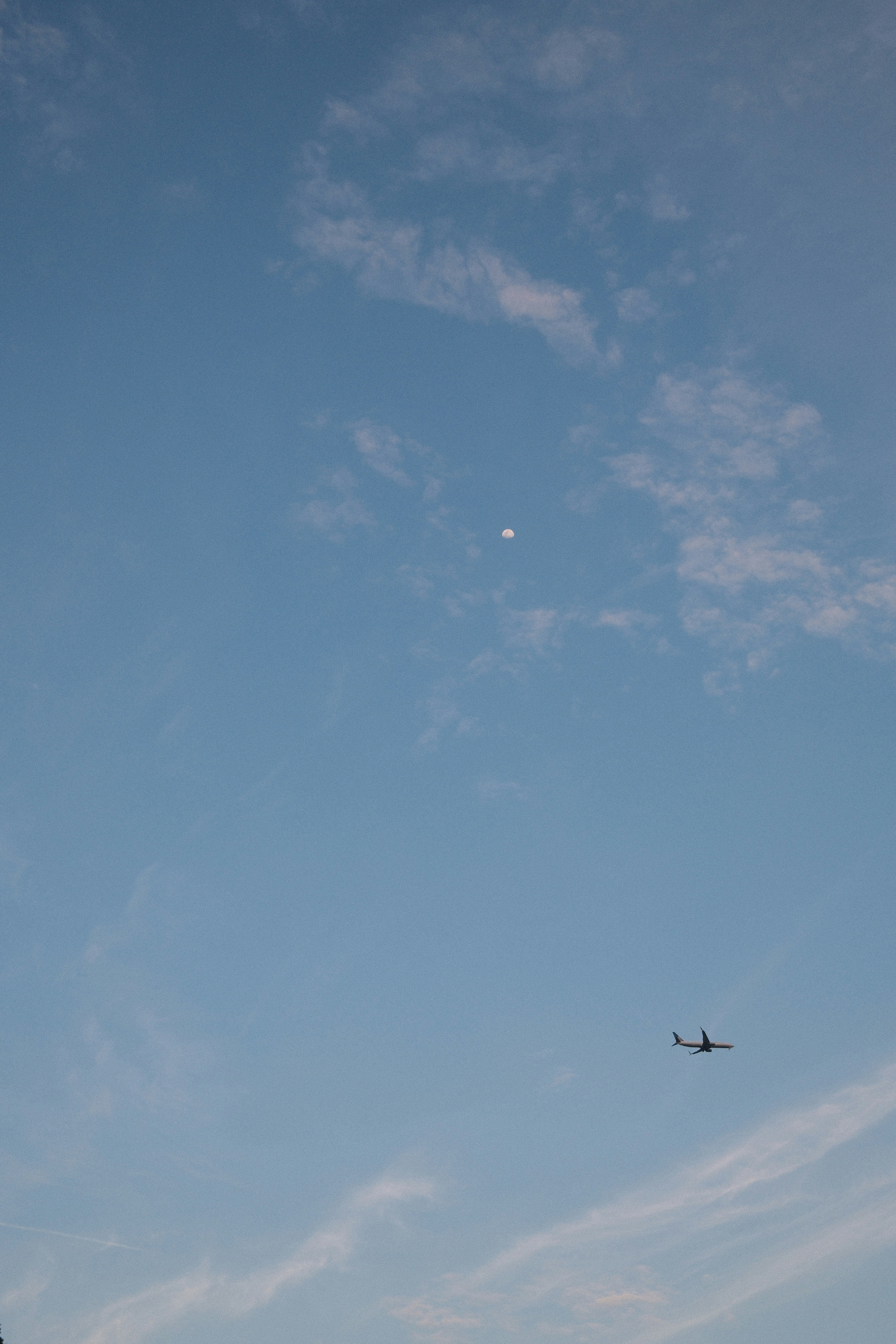 an airplane flying in the sky with a moon in the background