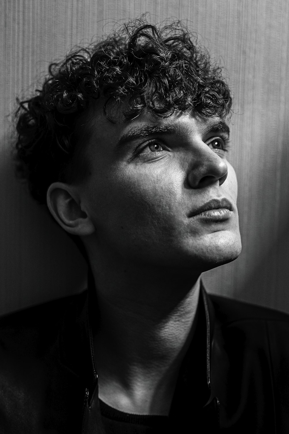 a black and white photo of a man with curly hair