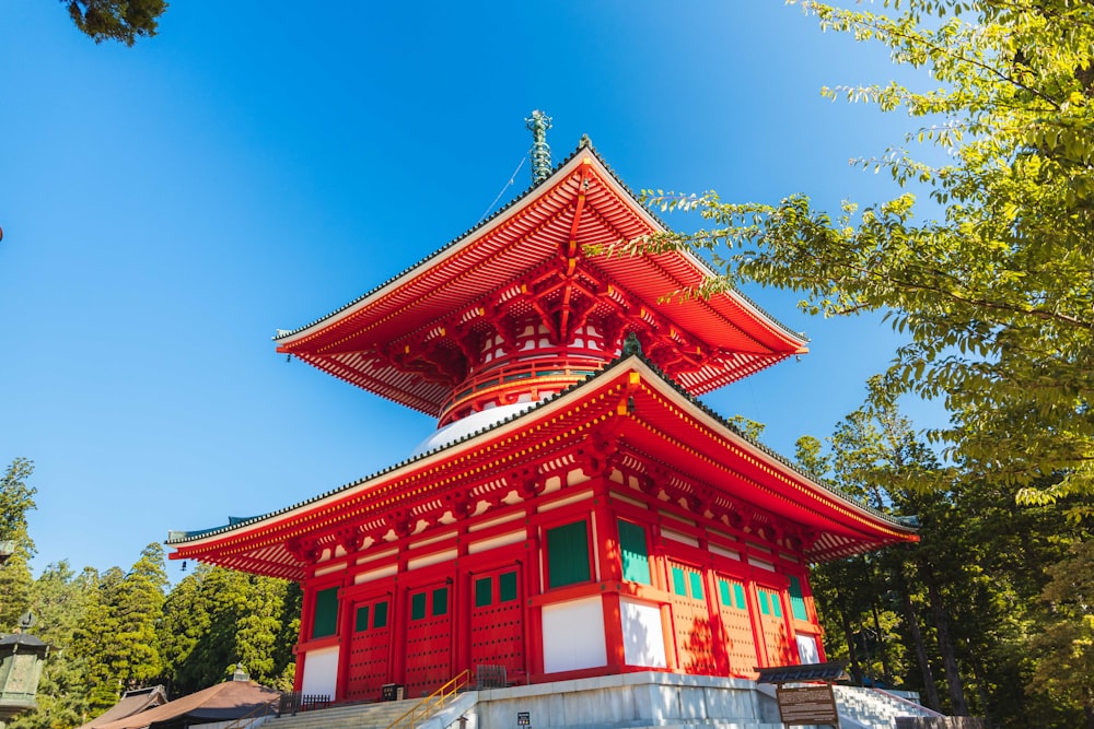 a tall red building sitting next to a forest