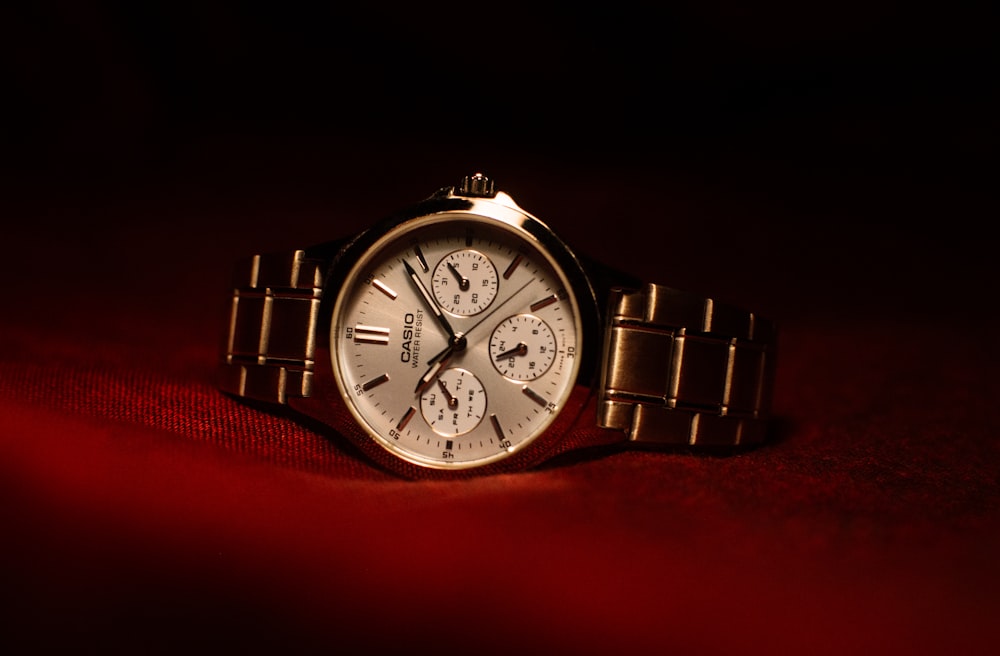a watch sitting on top of a red cloth
