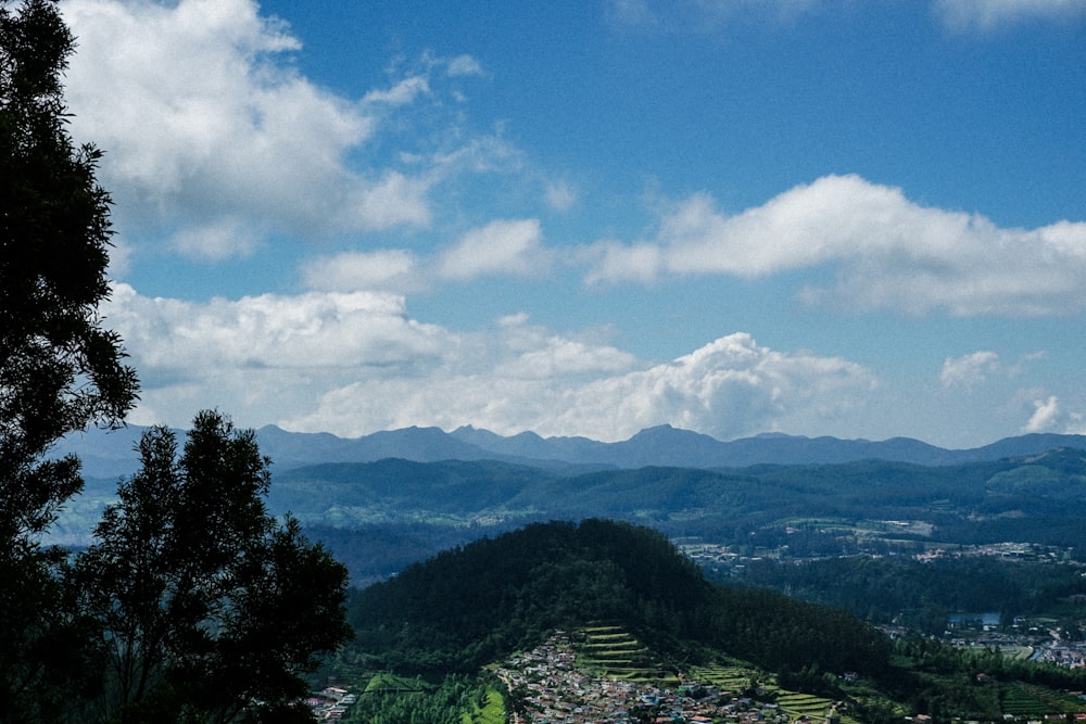 a scenic view of a city with mountains in the background