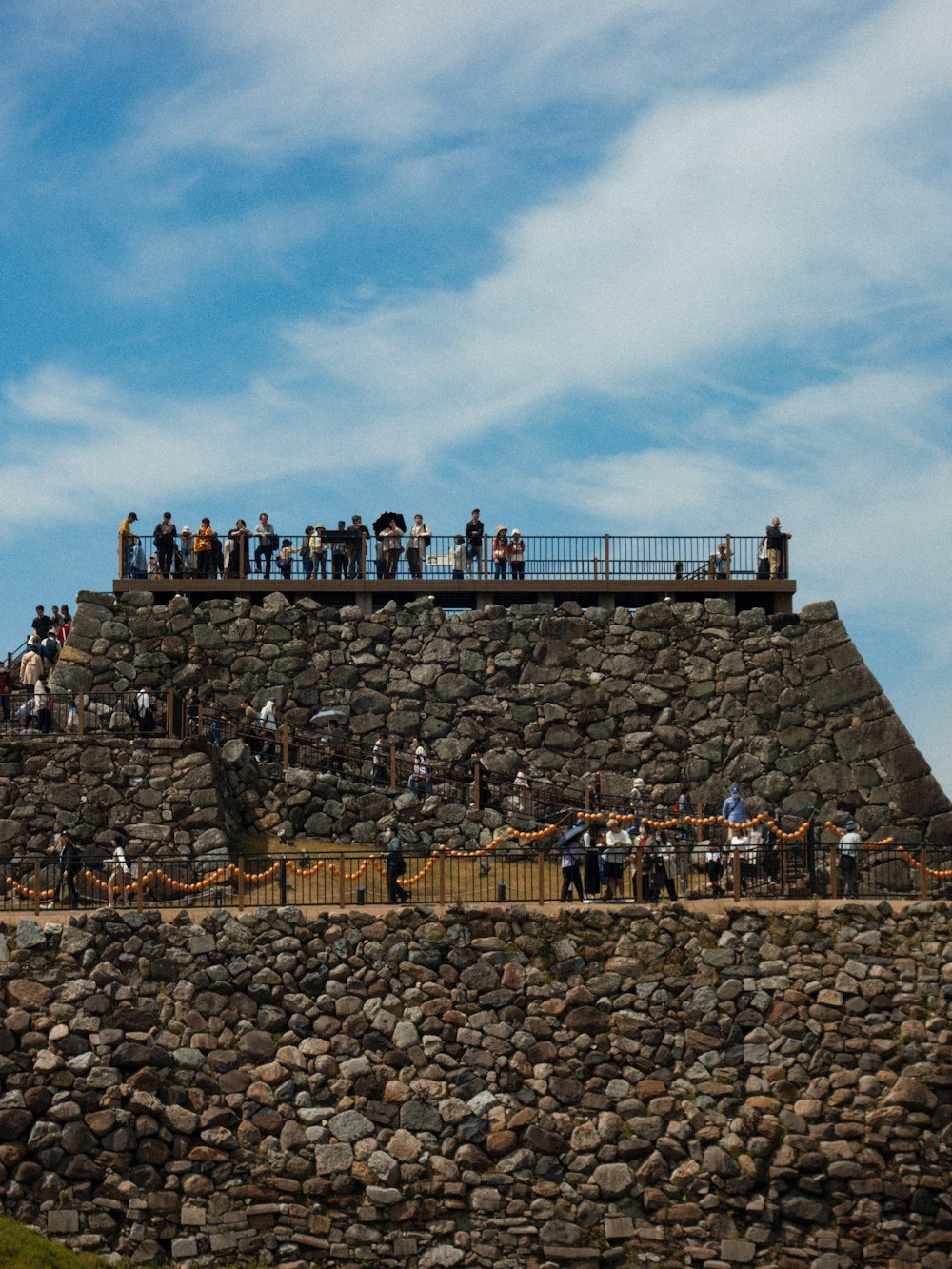 a group of people standing on top of a stone wall