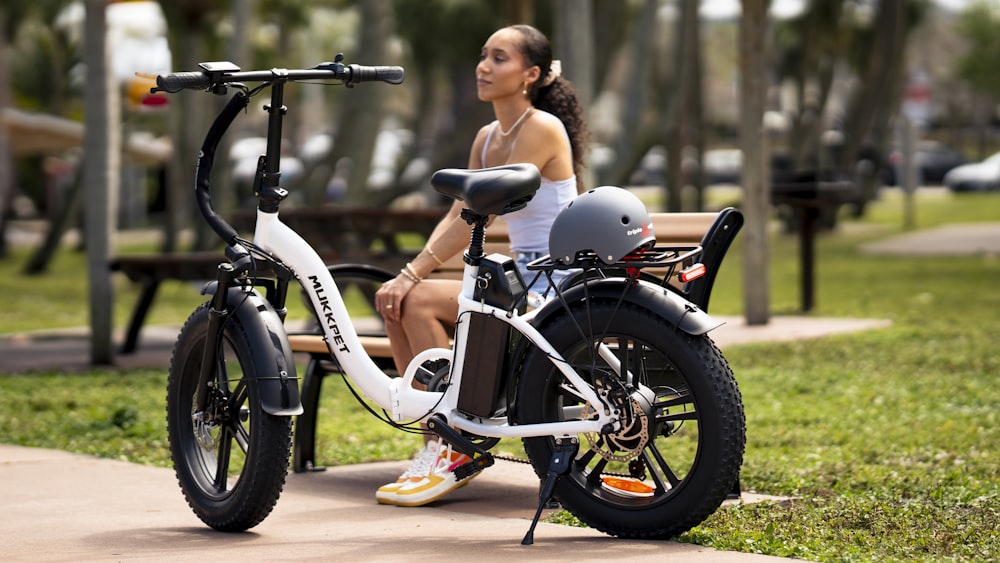 a woman sitting on a bench next to a bike