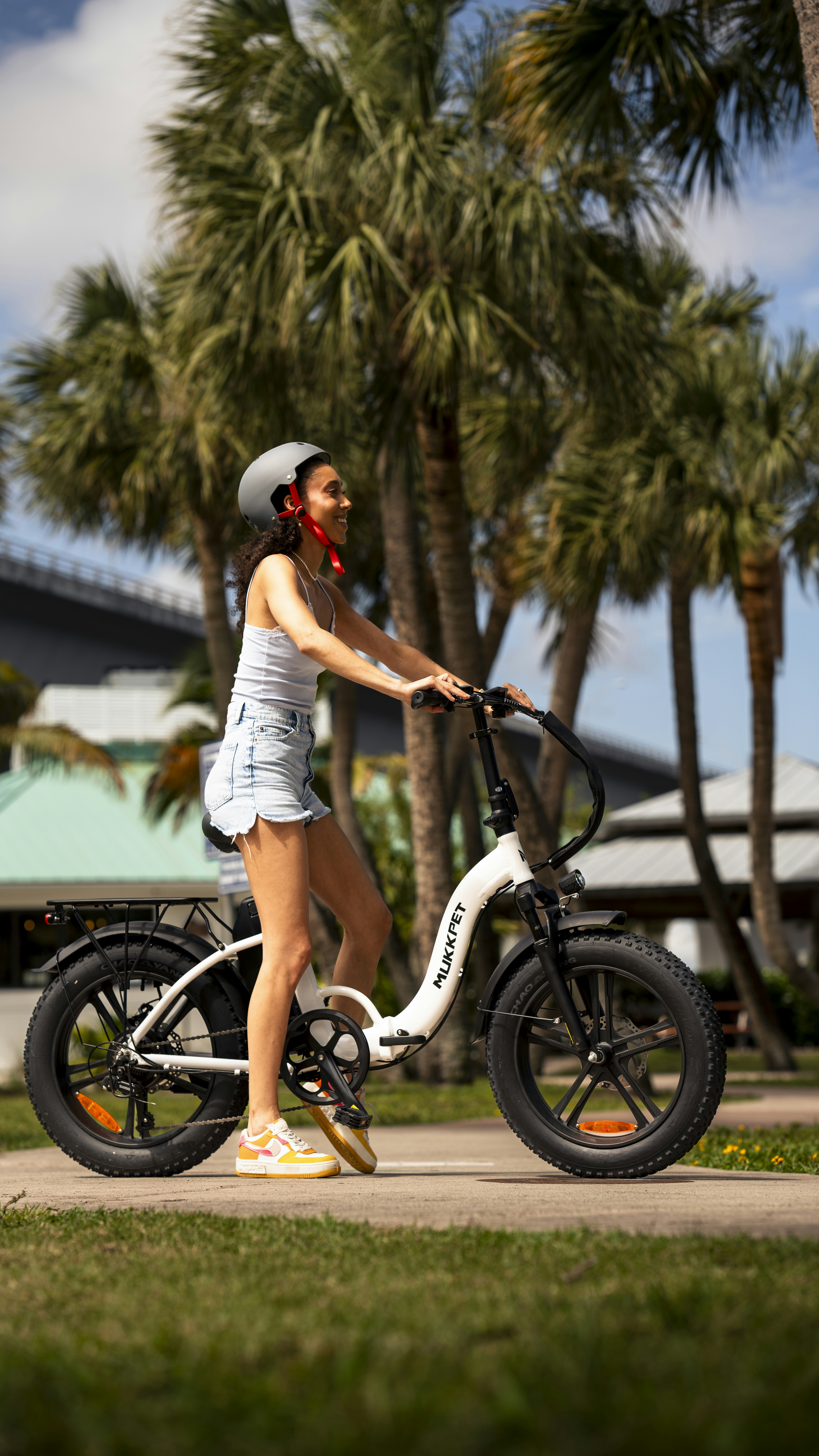 a woman riding a bike down a sidewalk