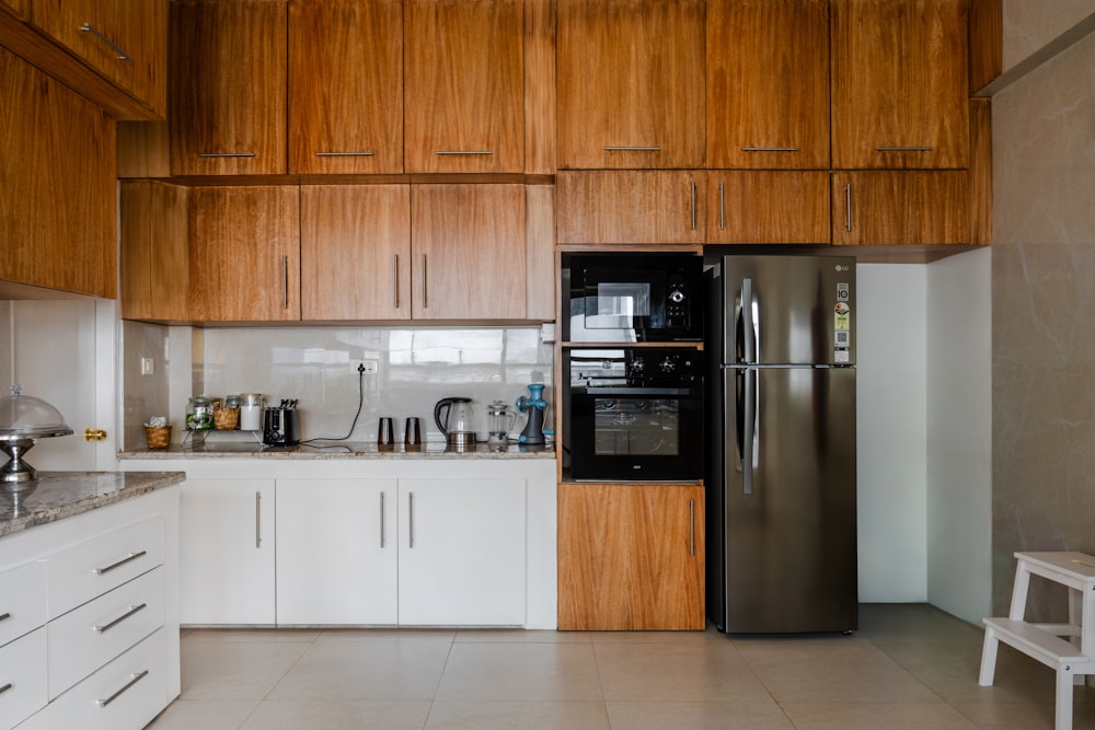 una cocina con gabinetes blancos y un refrigerador negro