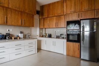 a kitchen with a refrigerator, stove, microwave and cabinets