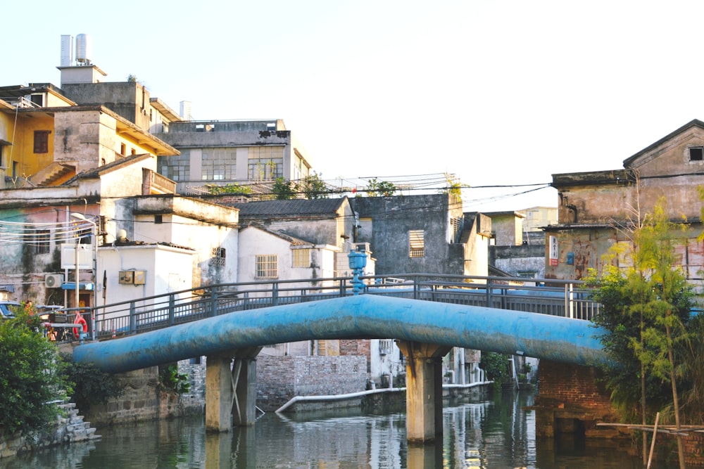 a bridge over a body of water with buildings in the background