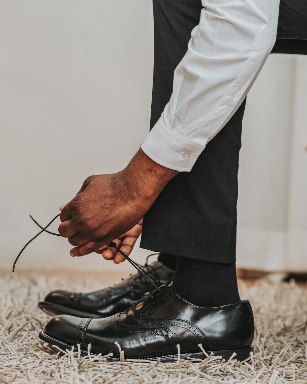 a close up of a person tying a pair of shoes