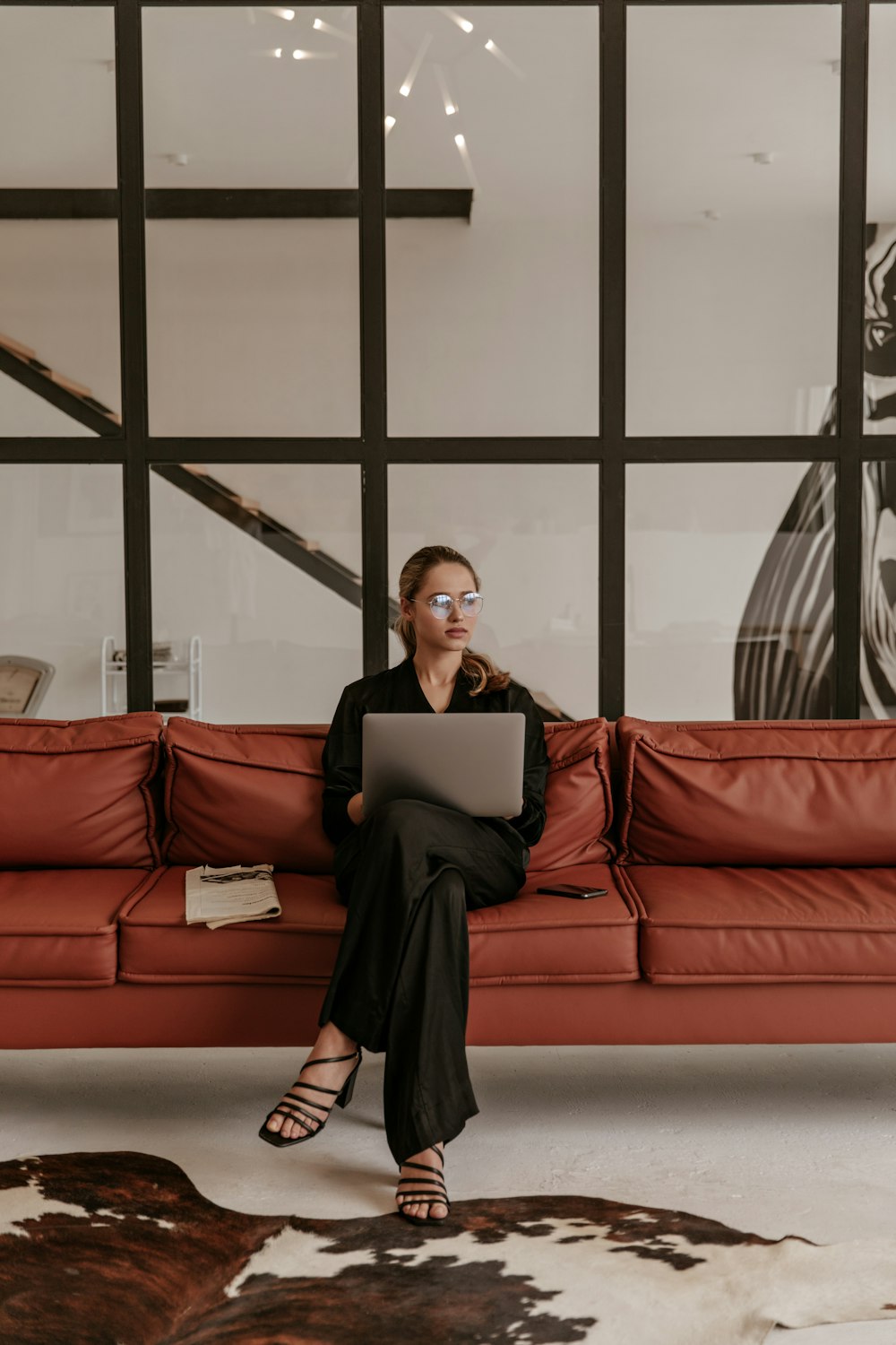 a woman sitting on a couch using a laptop