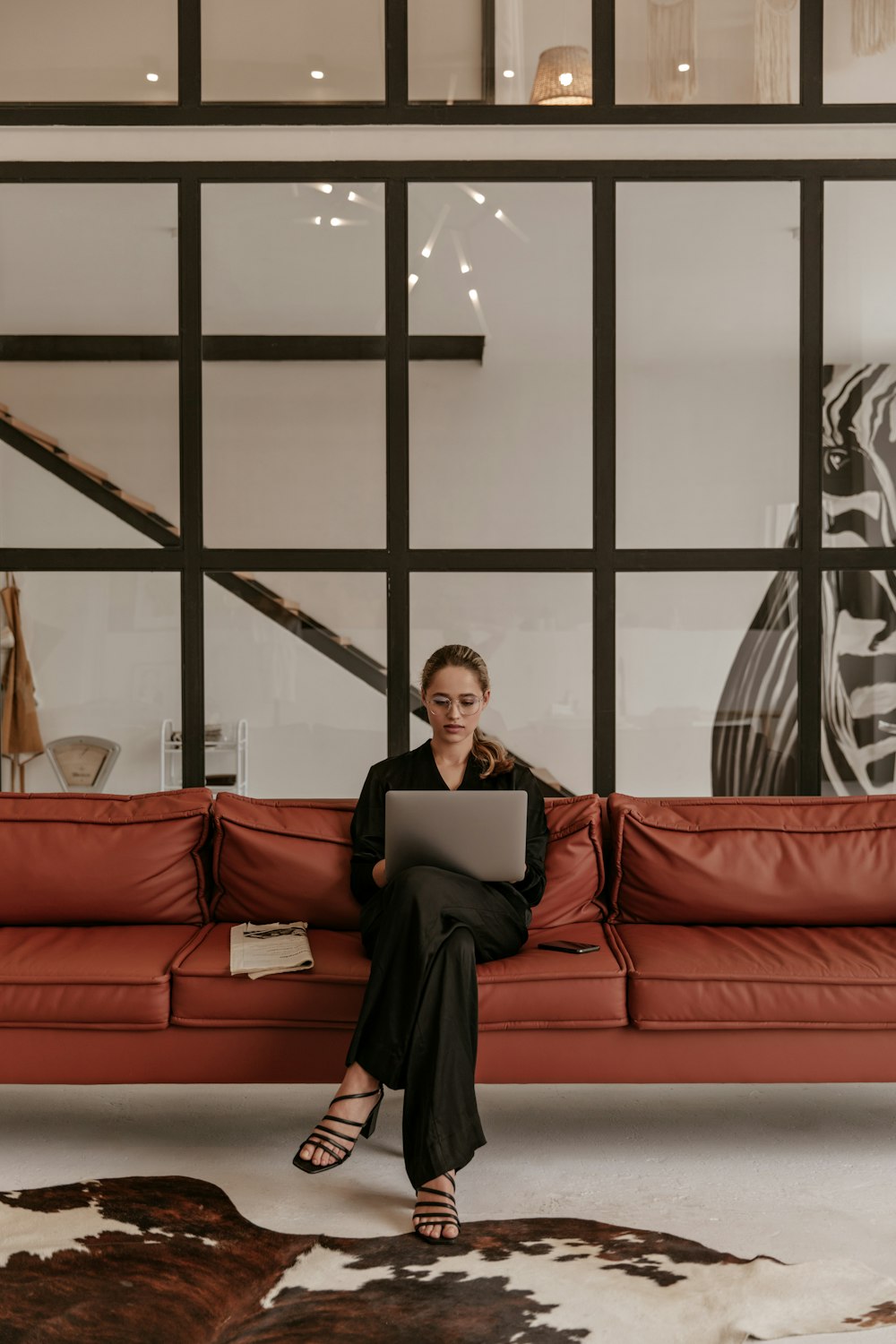 a woman sitting on a couch using a laptop