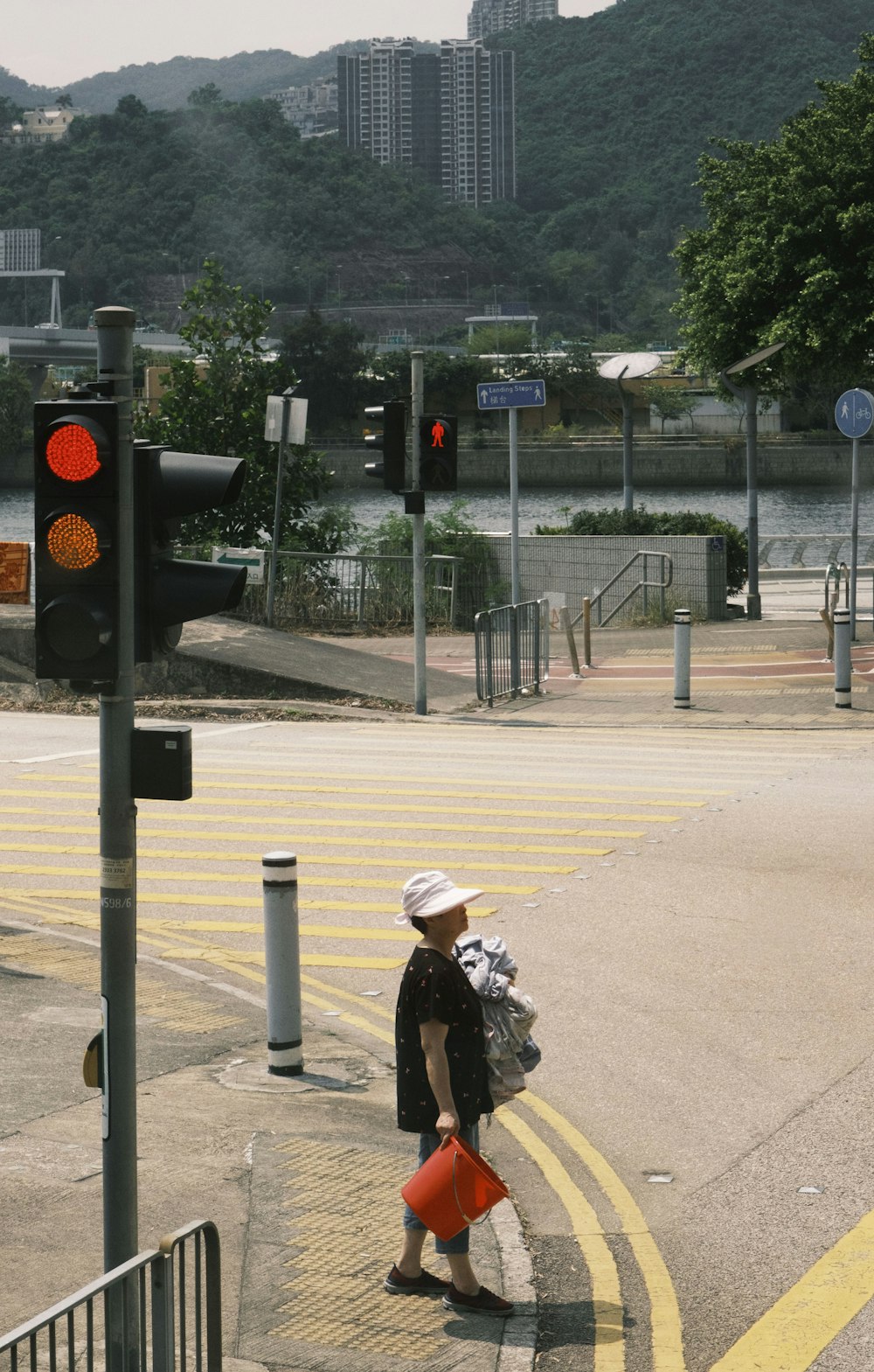 a woman walking down a street next to a traffic light