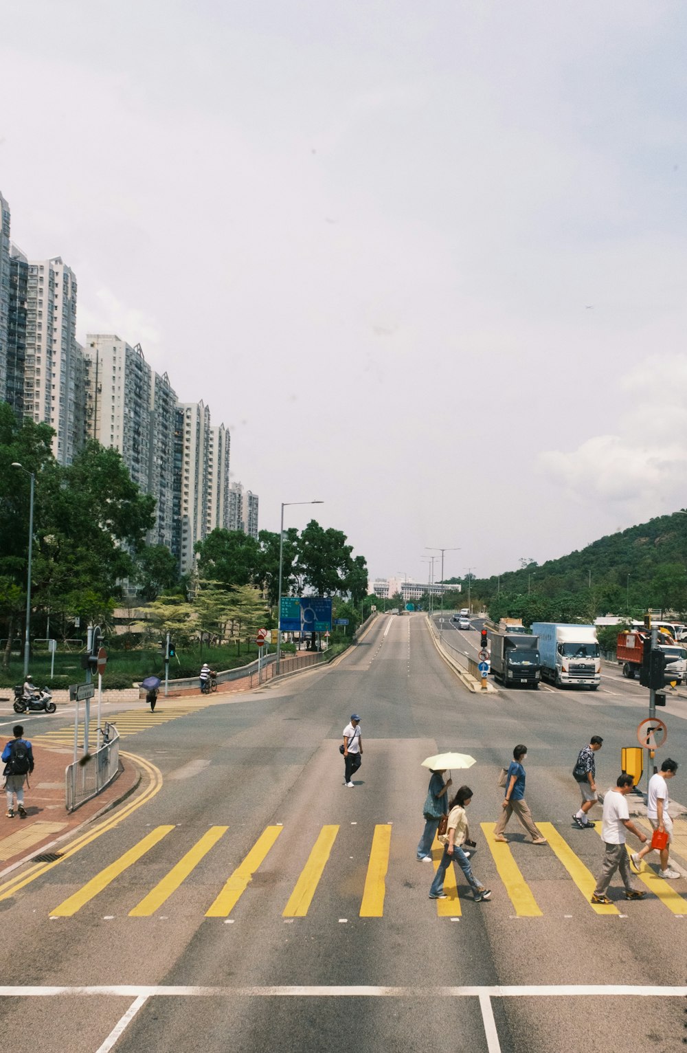 a group of people crossing a street with umbrellas