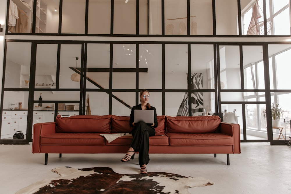 a woman sitting on a couch using a laptop