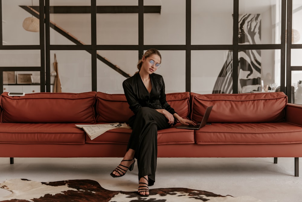 a woman sitting on a couch with a laptop