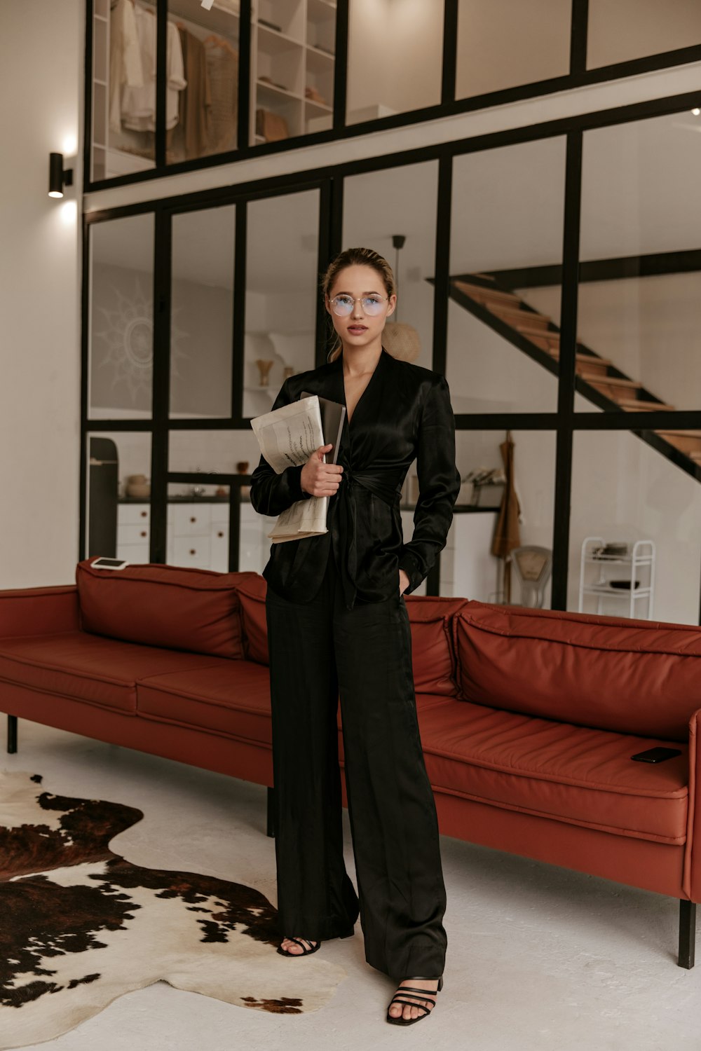 a woman standing in front of a red couch