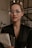 a woman wearing glasses holding a folder