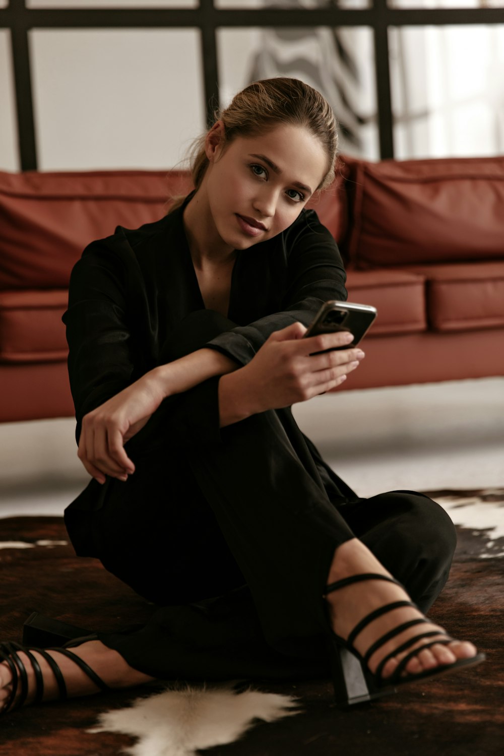 a woman sitting on the floor looking at her cell phone