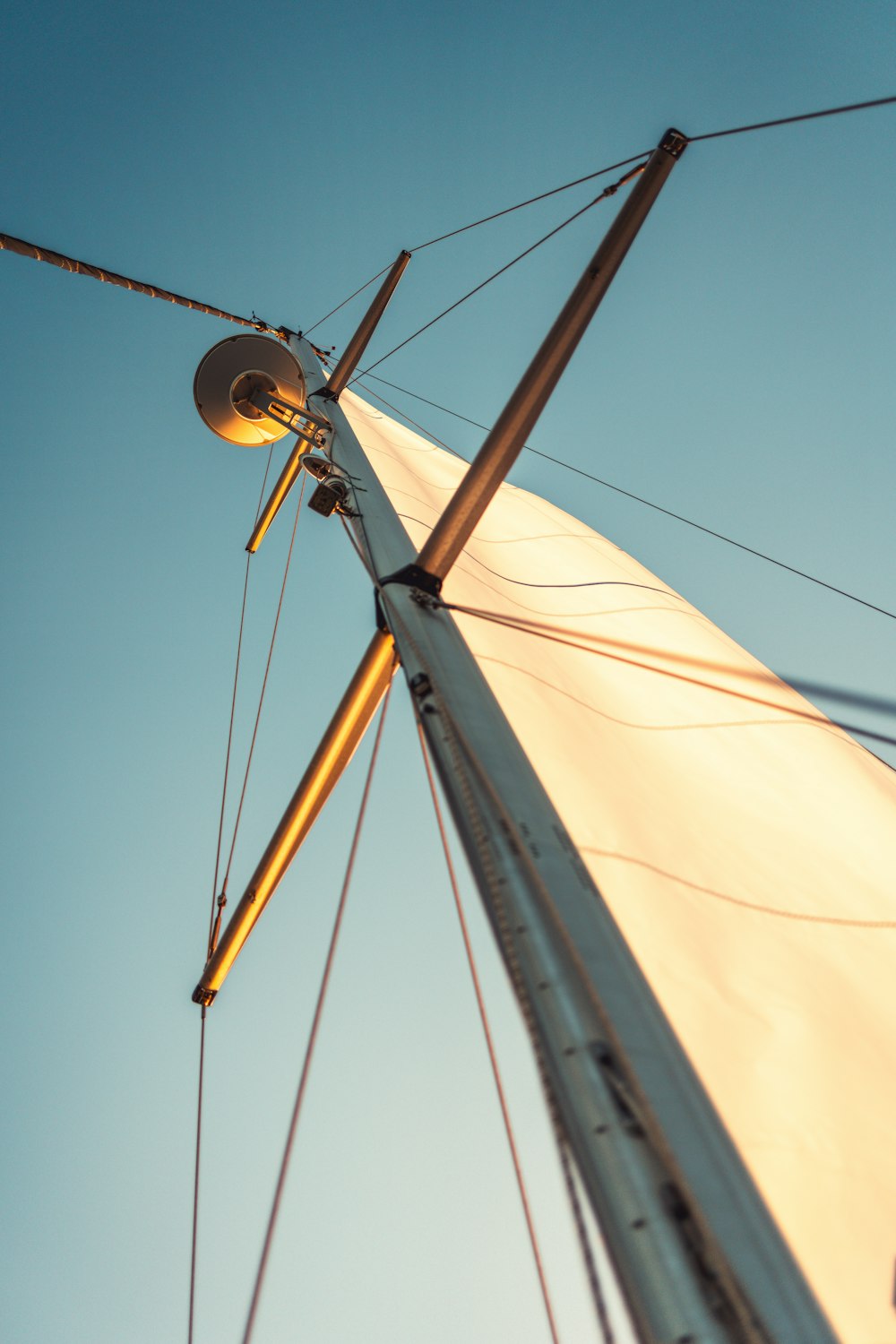 the mast of a sailboat against a blue sky