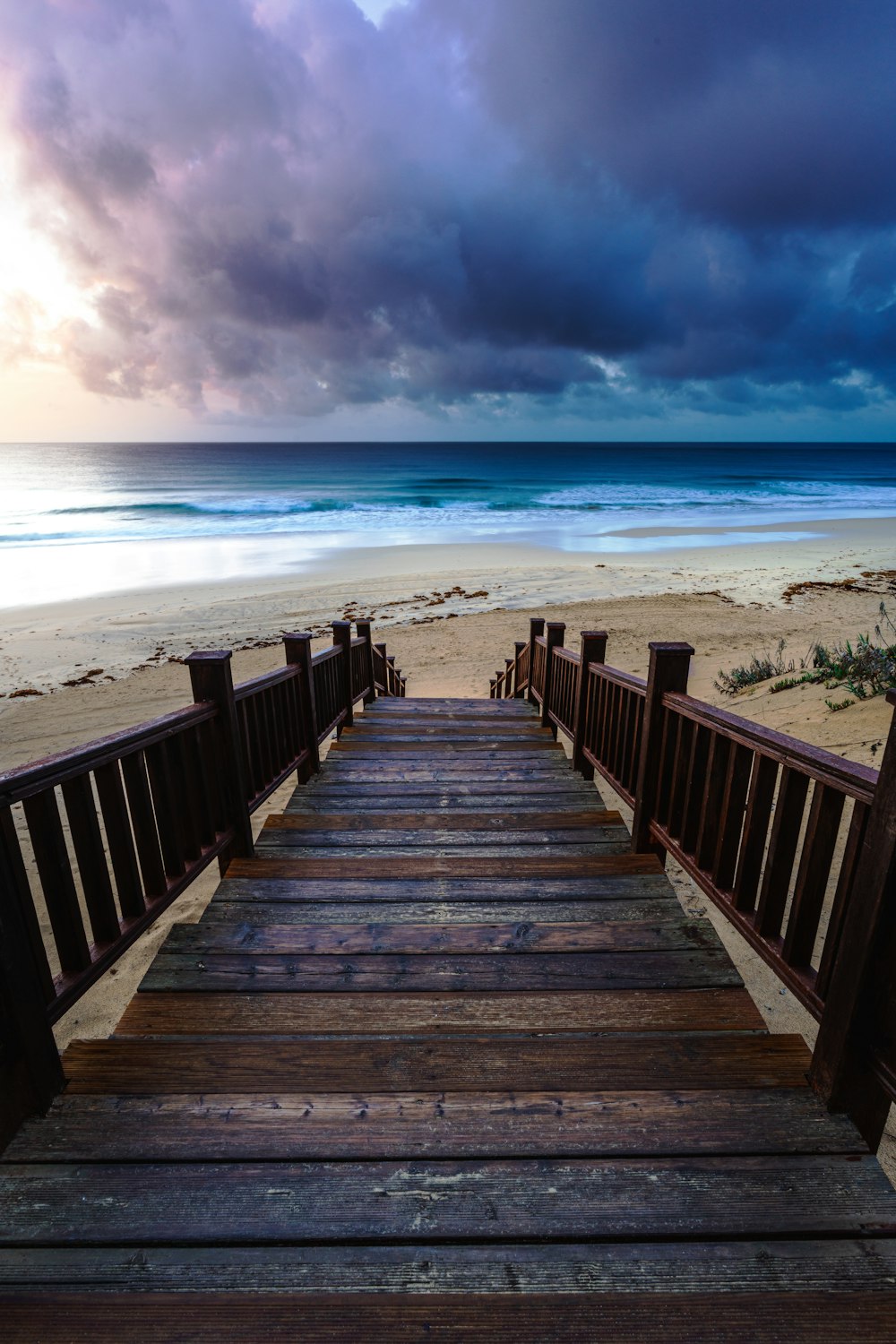 a set of wooden stairs leading to the beach
