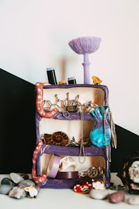 a purple suitcase with jewelry on top of it