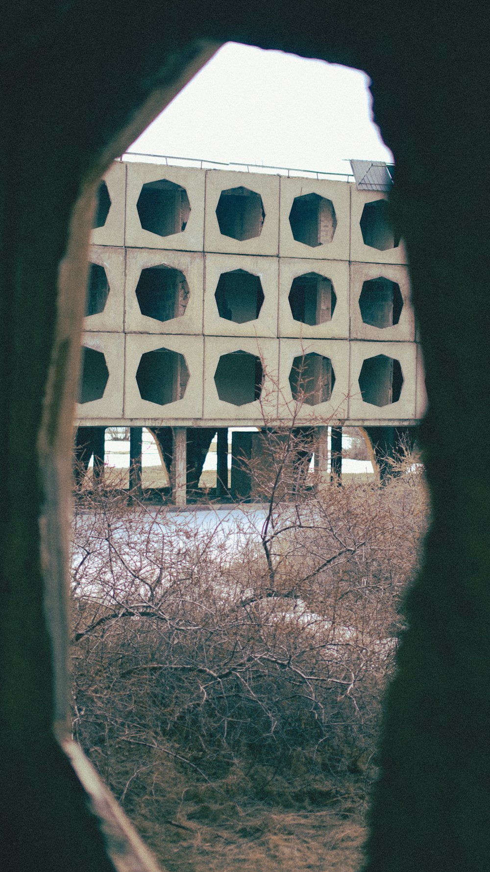 a view of a building through a hole in a wall
