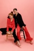 two women sitting on a chair posing for a picture