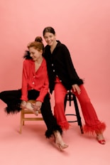 two women sitting on a chair posing for a picture